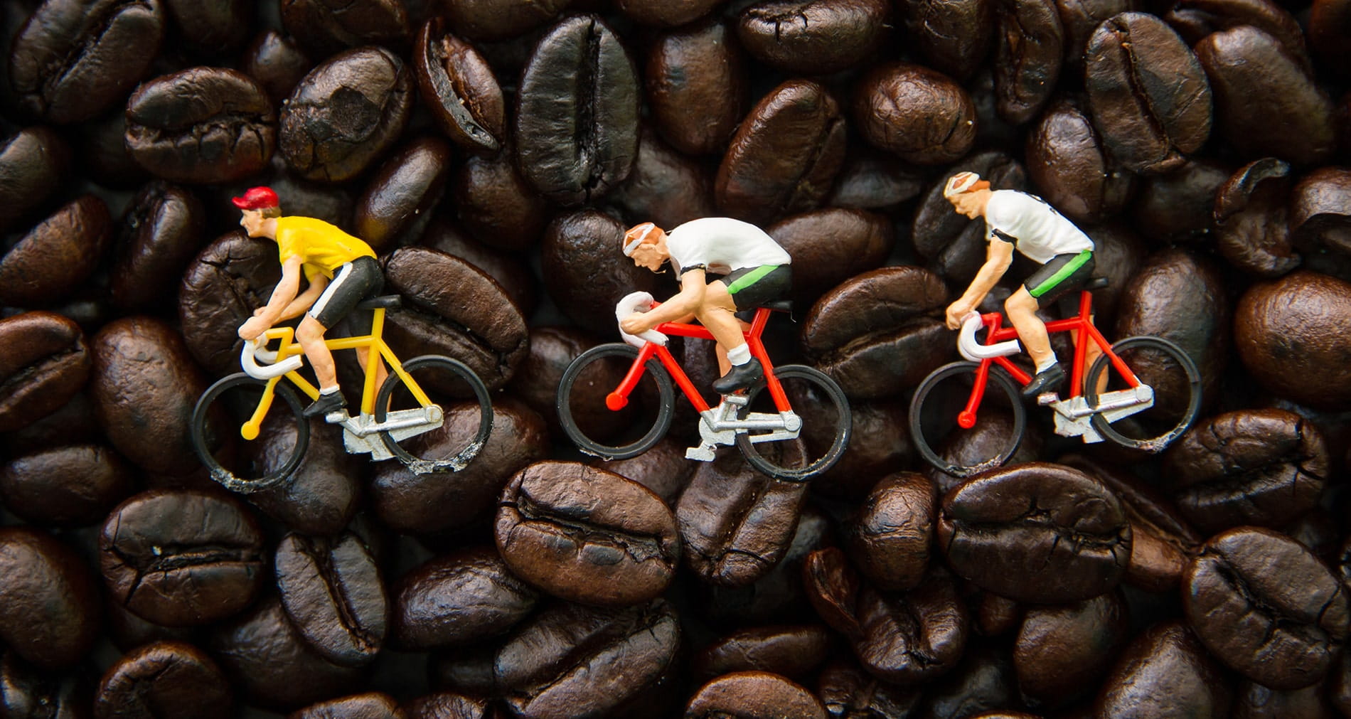 Three cycling figures on coffee beans